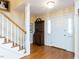 Entryway featuring hardwood floors, white trim, statement light fixture and staircase leading to second floor at 11 Whitburn Pl, Durham, NC 27705