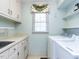 Bright laundry room features a window, white cabinets, and modern washer and dryer at 11 Whitburn Pl, Durham, NC 27705