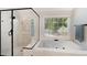 A luxurious bathroom has a glass enclosed shower and soaking tub with a large window at 112 Aspenridge Dr, Holly Springs, NC 27540