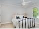 A well-lit bedroom boasts a cozy atmosphere, featuring a ceiling fan and a window for natural light at 112 Aspenridge Dr, Holly Springs, NC 27540