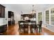 Dining area features dark wood table and chairs, hardwood floors and chandelier lighting at 112 Aspenridge Dr, Holly Springs, NC 27540
