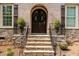 Close-up of the arched brick entryway with a stone staircase and decorative potted plants at 112 Aspenridge Dr, Holly Springs, NC 27540