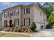 Side view of brick home showing the attached garage and manicured landscaping around the driveway at 112 Aspenridge Dr, Holly Springs, NC 27540