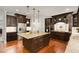 Gourmet kitchen features dark wood cabinets, granite countertops, a large island and stainless steel appliances at 112 Aspenridge Dr, Holly Springs, NC 27540