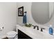Elegant powder room with a marble countertop, modern faucet, and decorative mirror at 112 Aspenridge Dr, Holly Springs, NC 27540