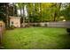 Large grassy backyard featuring a storage shed and wood fence at 112 E Edgewood Dr, Durham, NC 27704