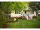 Charming home featuring a cozy front yard with a bench, green lawn, and tasteful landscaping at 112 E Edgewood Dr, Durham, NC 27704