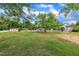 Large grassy backyard with mature trees, a shed, and a partial white fence at 112 Edmondson Dr, Willow Springs, NC 27592