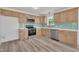 Bright kitchen with stainless steel appliances, wood cabinets, modern backsplash, and durable flooring at 112 Edmondson Dr, Willow Springs, NC 27592