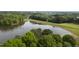 Aerial view of a lake surrounded by lush trees and greenery on a clear day at 115 White Lake Ct, Cary, NC 27519
