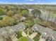 Aerial view showcasing charming homes near a scenic lake surrounded by lush trees and landscaping at 115 White Lake Ct, Cary, NC 27519