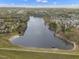 High angle aerial shot showcasing a tranquil lake surrounded by residential areas and lush trees at 115 White Lake Ct, Cary, NC 27519