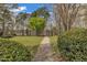 Scenic backyard with a path, lush greenery, and the tranquility of a lake view at 115 White Lake Ct, Cary, NC 27519