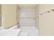 Well lit bathroom features a tub and shower combination with neutral colored tile and a granite shelf at 115 White Lake Ct, Cary, NC 27519