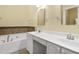 Bright bathroom features a double vanity, soaking tub with decorative tile surround and neutral paint at 115 White Lake Ct, Cary, NC 27519