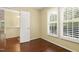 This bedroom has hardwood floors, plantation shutters, and doorway access to another room at 115 White Lake Ct, Cary, NC 27519