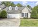 Charming home featuring a two-car garage, dormer windows, and manicured landscaping at 115 White Lake Ct, Cary, NC 27519