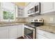 Bright kitchen features granite counters, stainless appliances, and classic white cabinetry at 115 White Lake Ct, Cary, NC 27519