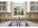Stainless steel sink with a view of the backyard from the kitchen window at 115 White Lake Ct, Cary, NC 27519
