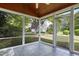 Screened-in patio with tile flooring and a view of the beautifully landscaped backyard at 115 White Lake Ct, Cary, NC 27519