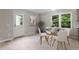 Bright dining area with modern table and chairs, large windows, and a stylish decorative tree at 1205 Freeman Dr, Sanford, NC 27330