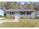 Charming single-story home featuring gray siding, a bright blue front door, and classic black shutters at 1205 Freeman Dr, Sanford, NC 27330