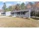 Inviting home with tidy front yard and light gray siding, accentuated by dark shutters and a bright blue door at 1205 Freeman Dr, Sanford, NC 27330