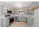 Modern kitchen features gray cabinets, stainless steel appliances, granite countertops, and tile backsplash at 1205 Freeman Dr, Sanford, NC 27330
