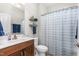 Bright bathroom with a patterned shower curtain, floating shelves, and a vanity with a marble countertop at 122 Tall Timber Dr, Gibsonville, NC 27249