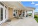 Spacious covered patio with ceiling fans, outdoor seating, and views of the well-maintained yard at 122 Tall Timber Dr, Gibsonville, NC 27249