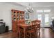A dining room with a wooden table and chairs, chandelier, and a wooden cabinet for displaying decorations at 122 Tall Timber Dr, Gibsonville, NC 27249