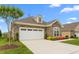 Single-story home featuring stone details, a two-car garage, and nicely kept landscaping at 122 Tall Timber Dr, Gibsonville, NC 27249