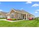 Beautiful single-story home featuring stone accents, well-manicured lawn, and vibrant flowerbeds at 122 Tall Timber Dr, Gibsonville, NC 27249