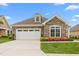 Charming single-story home with stone accents, attached garage, and colorful landscaping at 122 Tall Timber Dr, Gibsonville, NC 27249