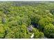 Expansive aerial view of the property, nestled among lush trees, featuring a private pool and manicured lawn at 12200 Glenlivet Way, Raleigh, NC 27613