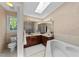 Bathroom featuring a skylight, a soaking tub, and a double sink vanity at 12200 Glenlivet Way, Raleigh, NC 27613