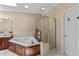 Bathroom featuring a large soaking tub, glass-enclosed shower, and neutral tile at 12200 Glenlivet Way, Raleigh, NC 27613