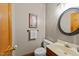 Powder room with a toilet, mirror, and sink with marble counter tops at 12200 Glenlivet Way, Raleigh, NC 27613