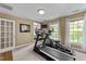 Carpeted bedroom with exercise equipment, walk-in closet, and natural light at 12200 Glenlivet Way, Raleigh, NC 27613