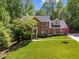 Beautiful brick home with a well-manicured lawn and mature trees on a sunny day at 12200 Glenlivet Way, Raleigh, NC 27613