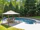 Relaxing pool area with gazebo and table, surrounded by lush greenery, perfect for outdoor enjoyment at 12200 Glenlivet Way, Raleigh, NC 27613