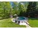 Backyard pool area, surrounded by lush trees, patio furniture and an umbrella at 12200 Glenlivet Way, Raleigh, NC 27613