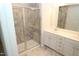 Bathroom featuring a glass enclosed shower, granite tile surround and double sink vanity at 123 Hunston Dr, Holly Springs, NC 27540