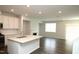 Stylish kitchen with white cabinets, stainless appliances, island, open to living area at 123 Hunston Dr, Holly Springs, NC 27540