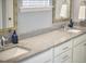 This bathroom features double sinks, granite countertops, white cabinets, and updated fixtures at 1238 Exchange Pl, Durham, NC 27713