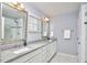 This bathroom features double sinks, granite countertops, white cabinets, and a glass door shower at 1238 Exchange Pl, Durham, NC 27713