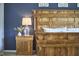 This bedroom features a rustic wood bed frame, a blue accent wall, and a wooden nightstand with a glass lamp at 1238 Exchange Pl, Durham, NC 27713