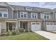 Charming townhome showcasing a stone facade, attached garage, and inviting curb appeal with manicured lawn at 1238 Exchange Pl, Durham, NC 27713