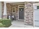 Inviting front porch with stone accents, features seating, and a decorative wreath on the entry door at 1238 Exchange Pl, Durham, NC 27713