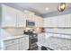Bright kitchen with white cabinetry, stainless steel appliances, and granite countertops at 1238 Exchange Pl, Durham, NC 27713
